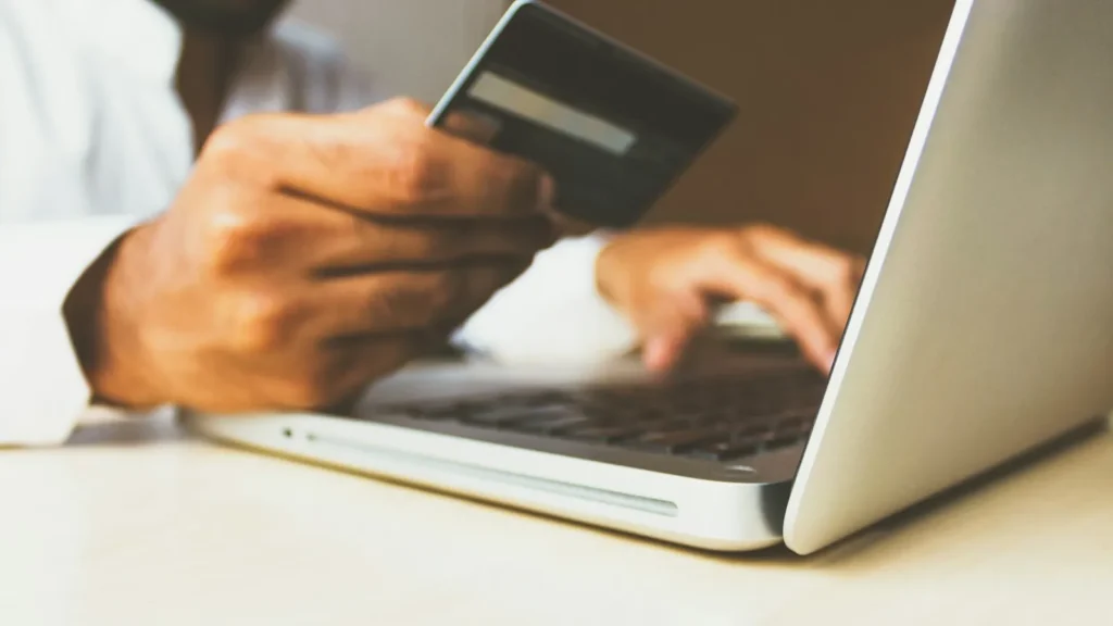 Pessoa contrata software com cartão corporativo no notebook, exemplo de shadow IT sem aval da TI