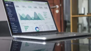 Notebook sobre mesa exibe dashboard com indicadores de TI em gráficos