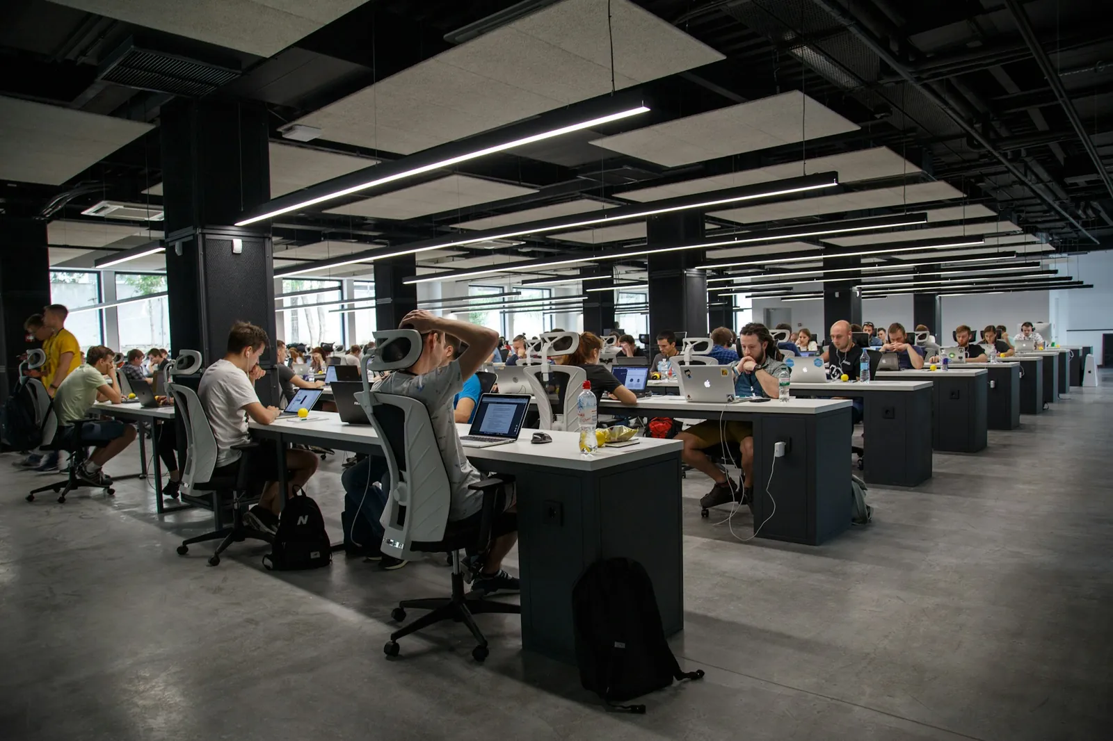 Equipe de TI trabalha em escritório atendendo chamados em várias telas