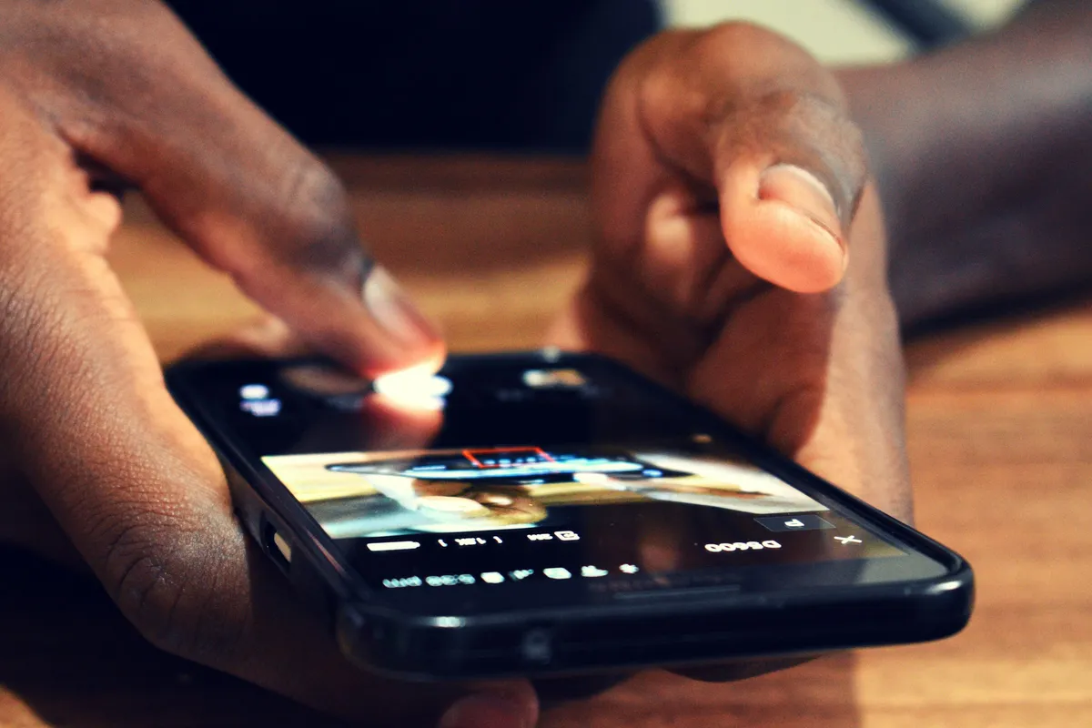 Pessoa usa smartphone pessoal no ambiente de trabalho para acessar ferramenta de IA fora da rede da empresa